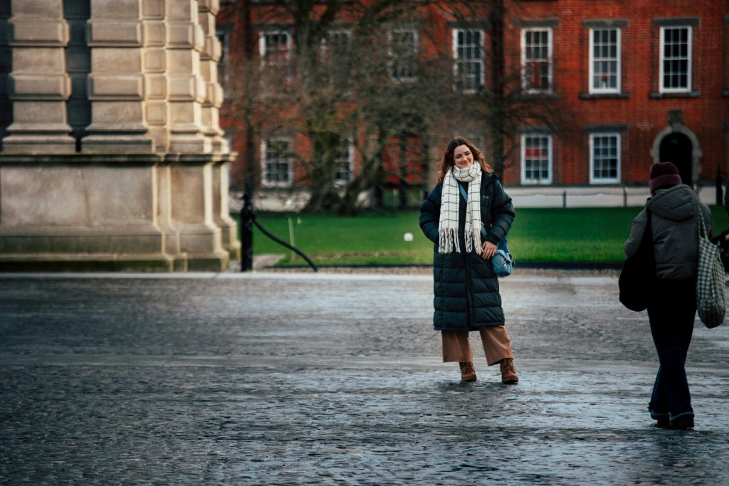 girl in a coat in front of tribity college dublin