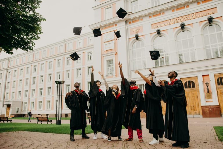 university students throwing hats on graduation day
