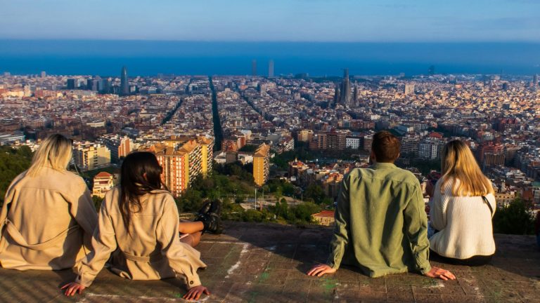 Students sitting above barcelona looking at the sea